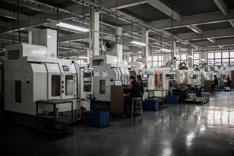 Row of CNC Milling machines with operators preparing