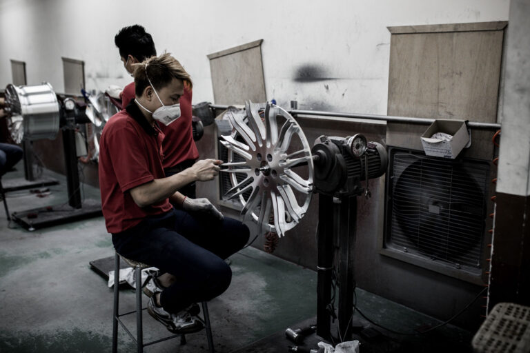 Workers prepping wheel face for finishing