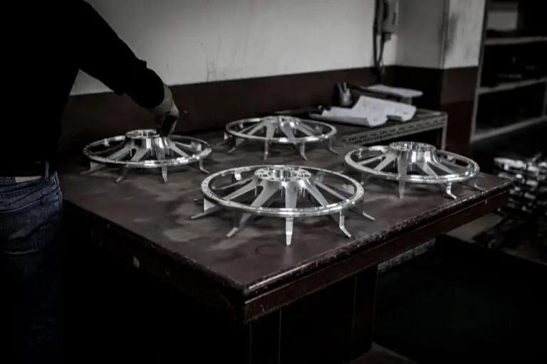 Worker inspecting completed set of wheel faces